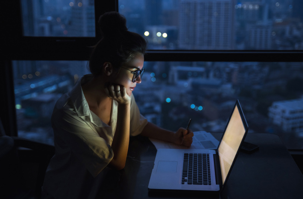 woman sitting at a desk at night working